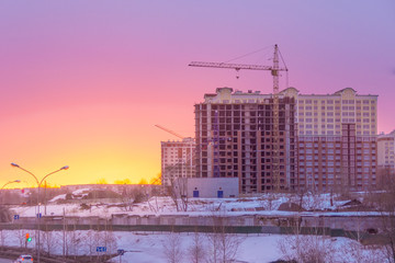 the construction of multi-storey residential buildings on the outskirts of the city, winter morning
