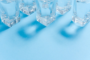 Glasses of water on blue. Close up. Copy space. Water balance for healthy and detox.