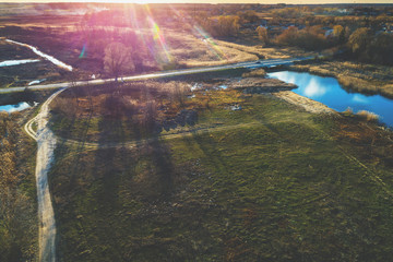 Aerial view of countryside and brook in evening at sunset light. Beautiful rural nature landscape