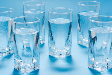 Glasses of clean water on color background