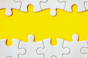 Puzzle pieces on yellow background. White square puzzle pieces grid. Business background. Top view,...