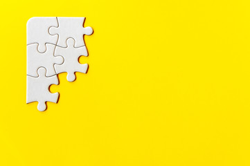 Puzzle pieces on yellow background. Quintuple piece flat puzzle. Business background. Copy space for text, top view.