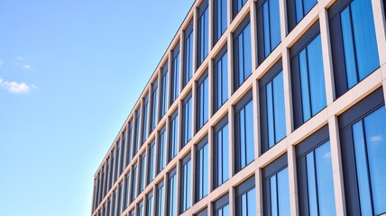 Modern office building windows with vertical lines and reflection. Building reflecting the sky with...