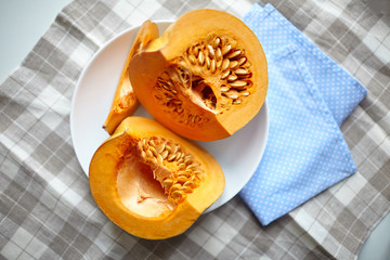 Pumpkin slices on a white plate on a table with napkin, top view