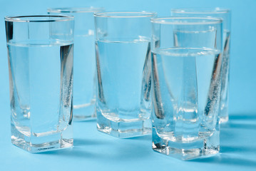 Glasses of clean water on color background