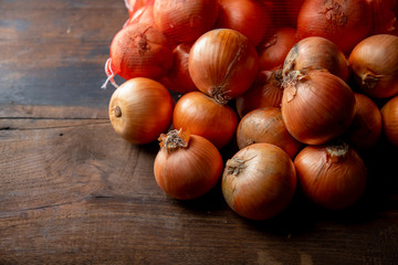 Fresh ripe onions on wood background.