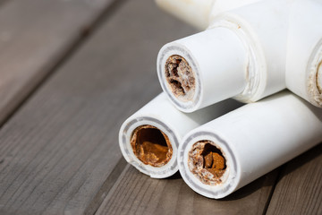 Old broken sludge polypropylene plumbing pipes with red rust and limescale. Corrosion, sludge and...