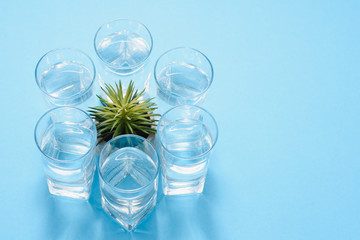 glasses with pure water and shadows on blue surface