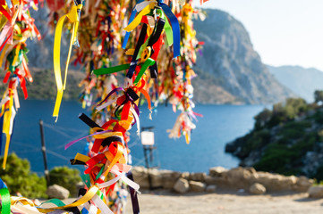 tree in festive colored ribbons on the background of the sea and mountains.