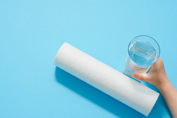 Water filters. Carbon cartridges and glasses on a blue background. Household filtration system.