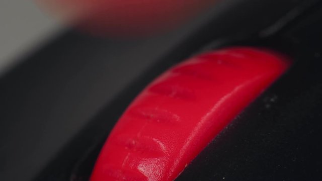 Macro finger scrolls and pushes presses the wheel on computer mouse. Surfing internet and social networks, reading news feed. Desk jockey or office monkey concept. Scrolling