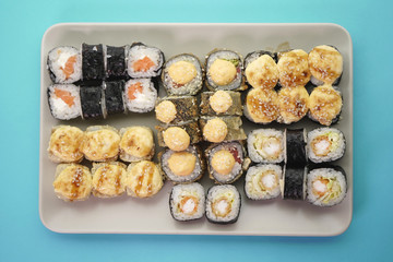 Many different sushi rolls on a plate on an isolated background.