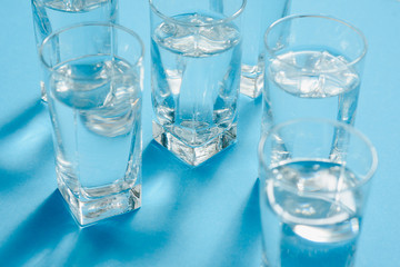 glasses with water on blue background. clean water concept