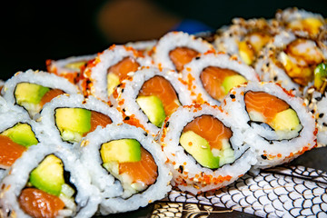 a selection of different types of salmon california sushi rolls served on top of a skateboard 