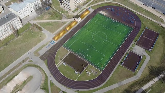 Football field. Sports Stadium, soccer lawn, basketball court and treadmills in the yard in the city 2.7K Aerial drone view