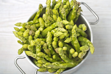 Green asparagus in pan, fresh bunch. Top view, selective focus