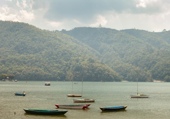Wooden rowboats idling on the Phewa Lake in the Himalayan city of Pokhara in Nepal.