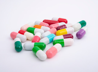 Different color pills on white background