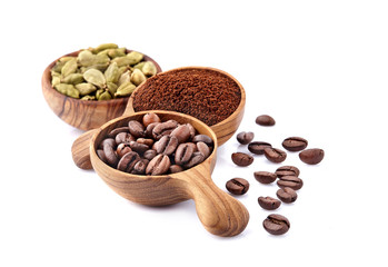 Coffee beans in a wooden spoon with  cardamom  on white background.