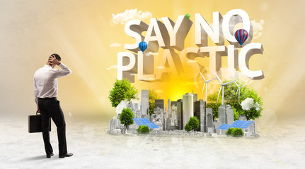 Rear view of a businessman standing in front of SAY NO PLASTIC inscription, Environmental protection concept