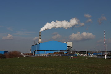 Fototapeta na wymiar Smoke comes out of the chimney of Asfalt Productie Rotterdam Rijnmond, a factory for creation asphalt in th port of Rotterdam