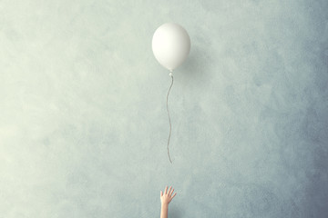 hand lets white balloon fly free - obrazy, fototapety, plakaty