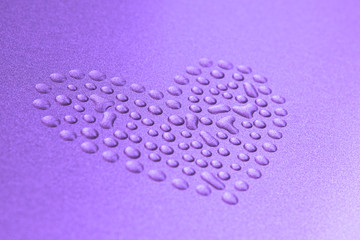 Blurry heart from water drops on metal surface