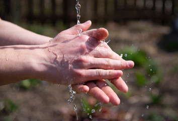  male hands under a stream of water .