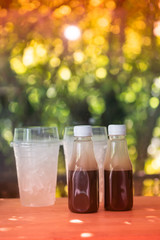Tasty cold coffee in plastic bottle on wood table