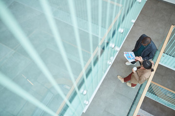 High angle view of African businessman consulting with his colleague about financial report