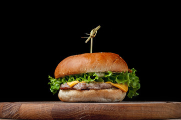 burger with a latch on a wooden board on a black background