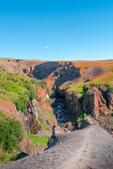 Beautiful and tall Icelandic waterfall Hengifoss and hiking trail to it, Iceland, summer, sunny day, blue sky
