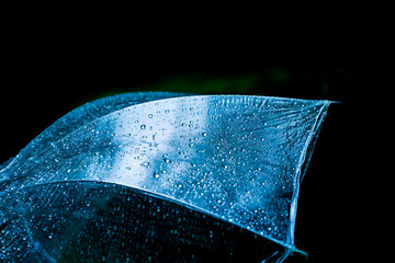 Rain drops on a clear umbrella.in Black background.shallow focus effect.