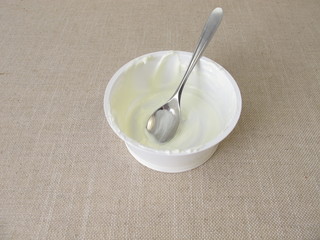 Empty plastic mug with remains of yogurt and a spoon