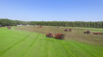 Farming tractors for cultivation and harvesting crops riding on green field
