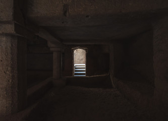 Light hitting the steps leading to the dark interiors of the ancient Buddhist Caves inside the Uparkot Fort.