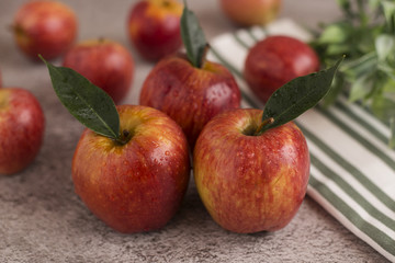  Red apples with leaves on a gray background