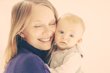Beautiful happy mother and child. Portrait of happy young mother holding adorable infant baby girl isolated on white background. Parenthood concept