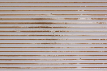 Background texture of plastic blinds covered with dust and dirt. Smudges and stains. White horizontal stripes.