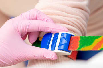 Nurse tightens the harness on the arm to take blood from a vein for analysis.