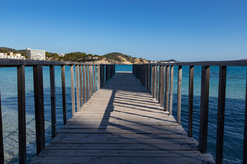 Fototapeta premium Wooden jetty in Mediterranean Sea at Son Matias, Mallorca during sunset, Spain