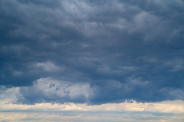Obraz premium dark grey cloudy sky with epic clouds above city. 