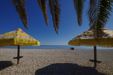 Two umbrellas open on a pebble beach