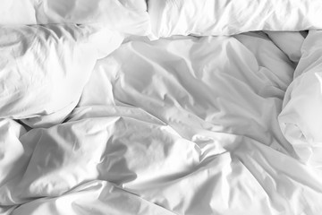 Closeup on black and white pillows and crumpled blanket in bedroom for Valentine backdrop.