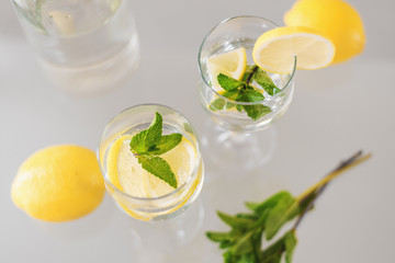 Two glasses of cocktail with lemon and mint, top view. Lemonade with herbs and fruit. Sparkling drink
