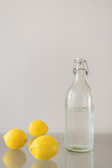 Fresh whole lemons and bottle of cold mineral water. Lemonade recipe