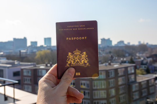 Dutch European paspoort with a clear blue sky and a city in the background