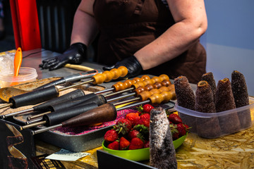 June 8, 2019, Gastrofestival, Yekaterinburg, Russia: Cook prepares hot trdelniki with cinnamon and strawberries. The national street food of the Czech Republic. Editorial photos