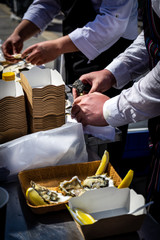 June 8, 2019, Gastronomic festival, Yekaterinburg, Russia: the chef opens oysters and pours lemon juice in the open air. Fresh and delicious seafood Breakfast.