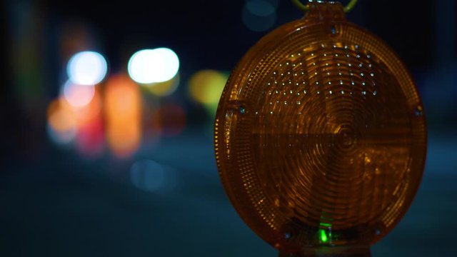 An amber lamp flashes in the night to warn motorists passing